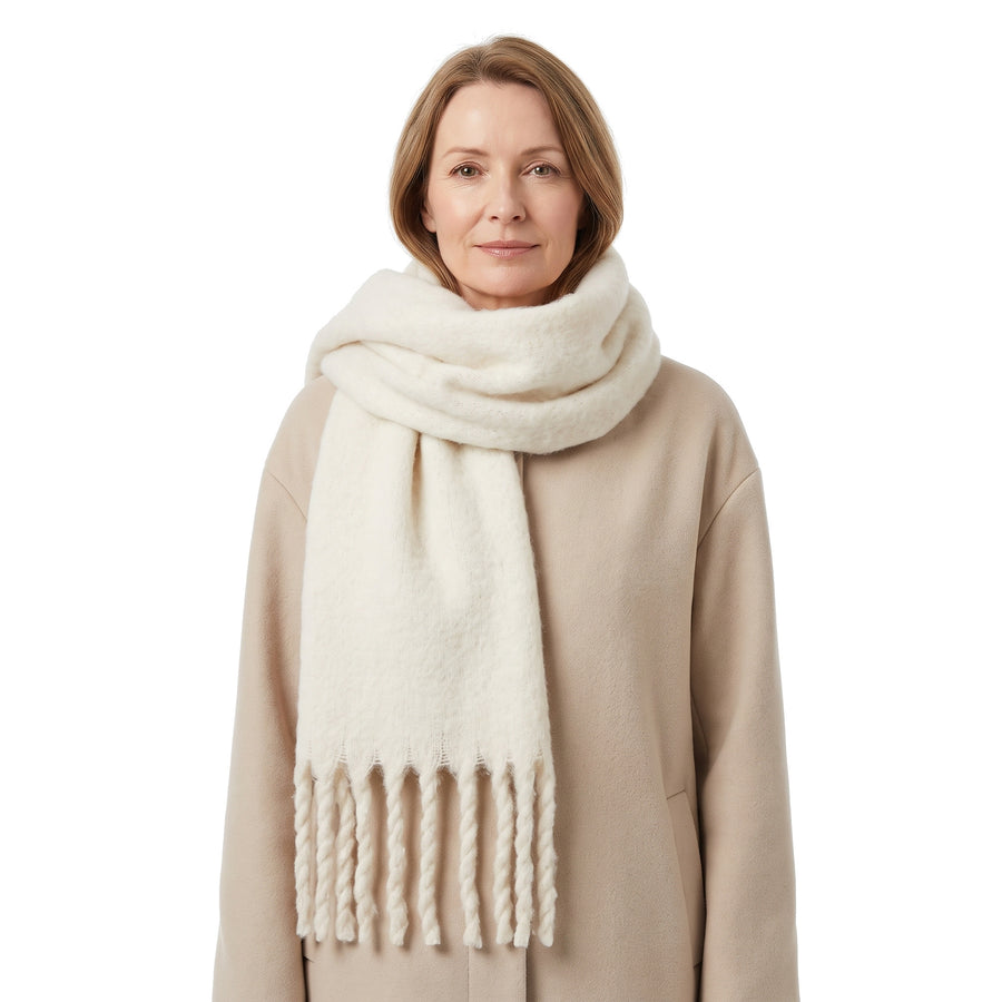 Women's oversized fringed wrap scarf in cream worn by a model