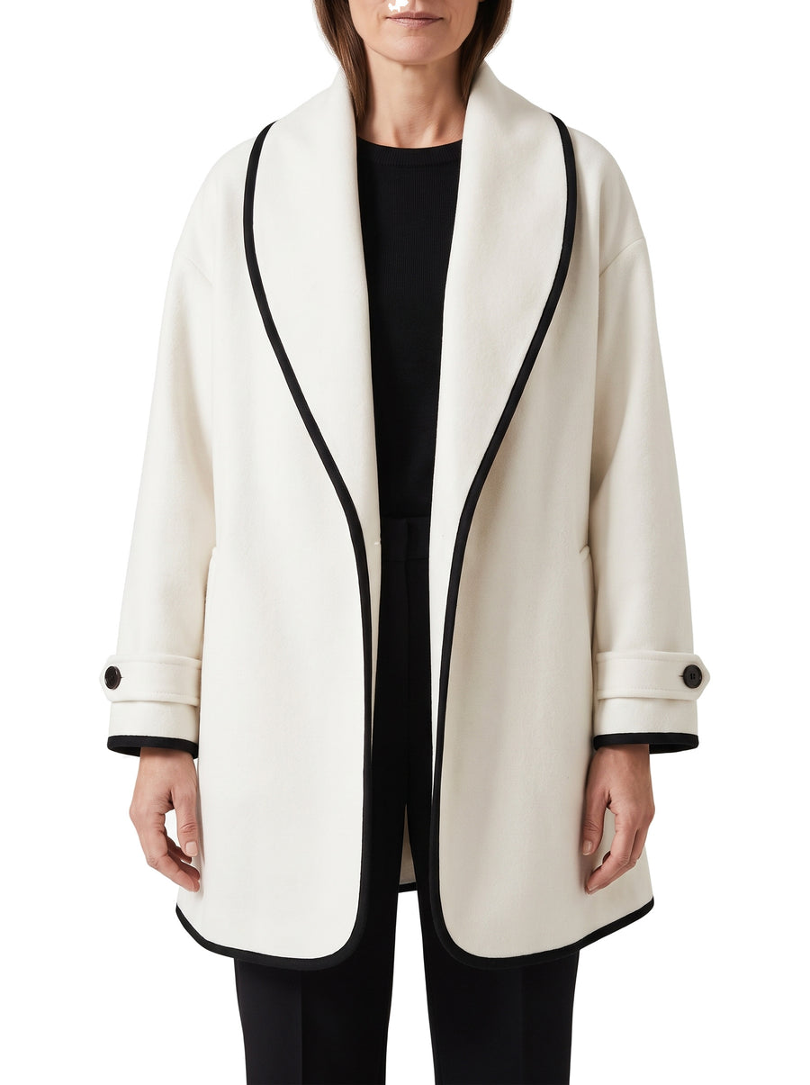 Women's oversized white wool trench coat with wide lapels and black trim