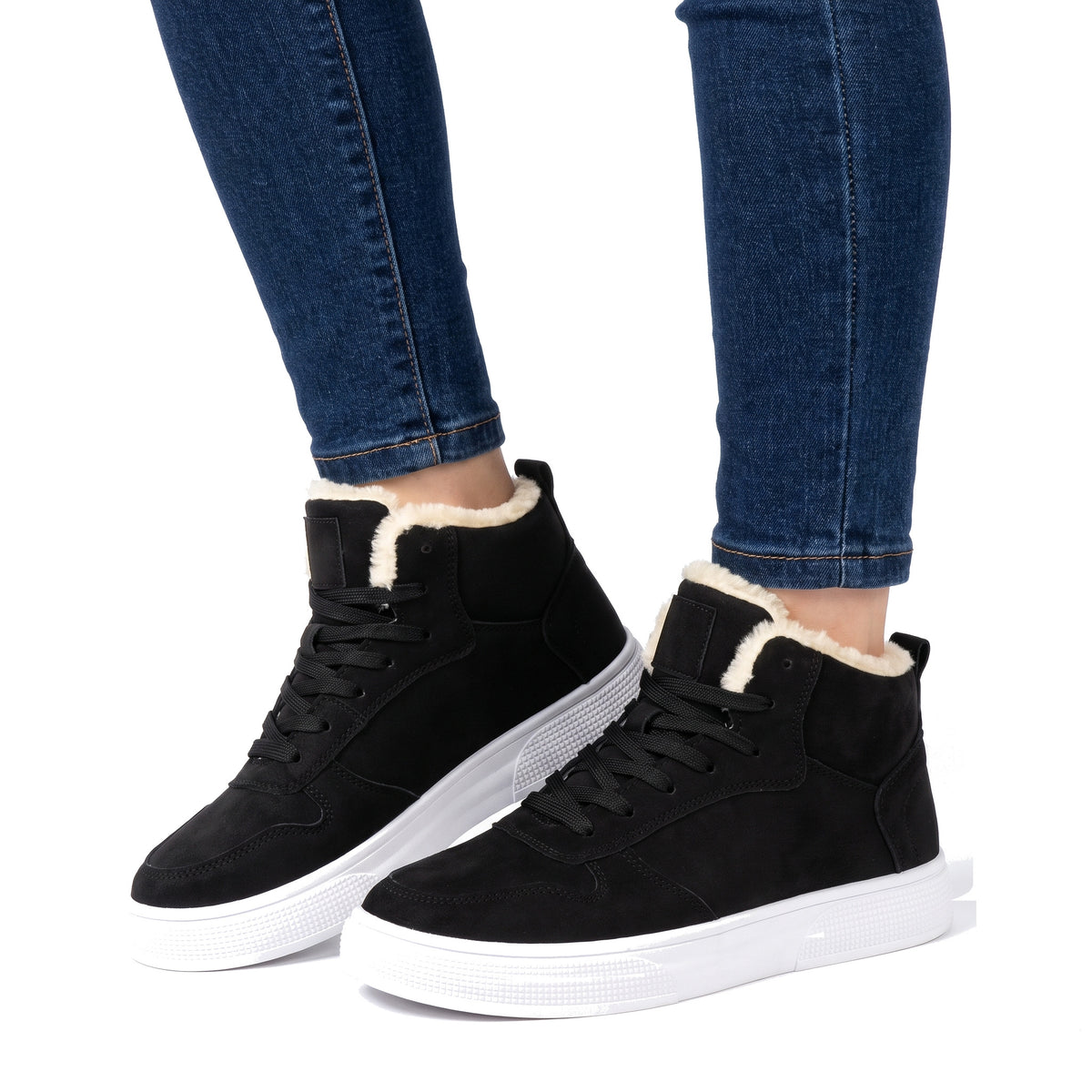 Women's warm-lined black high-top sneakers worn with dark jeans