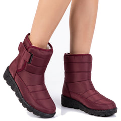 Women's fleece-lined wine red buckle-strap ankle boots worn, studio close-up