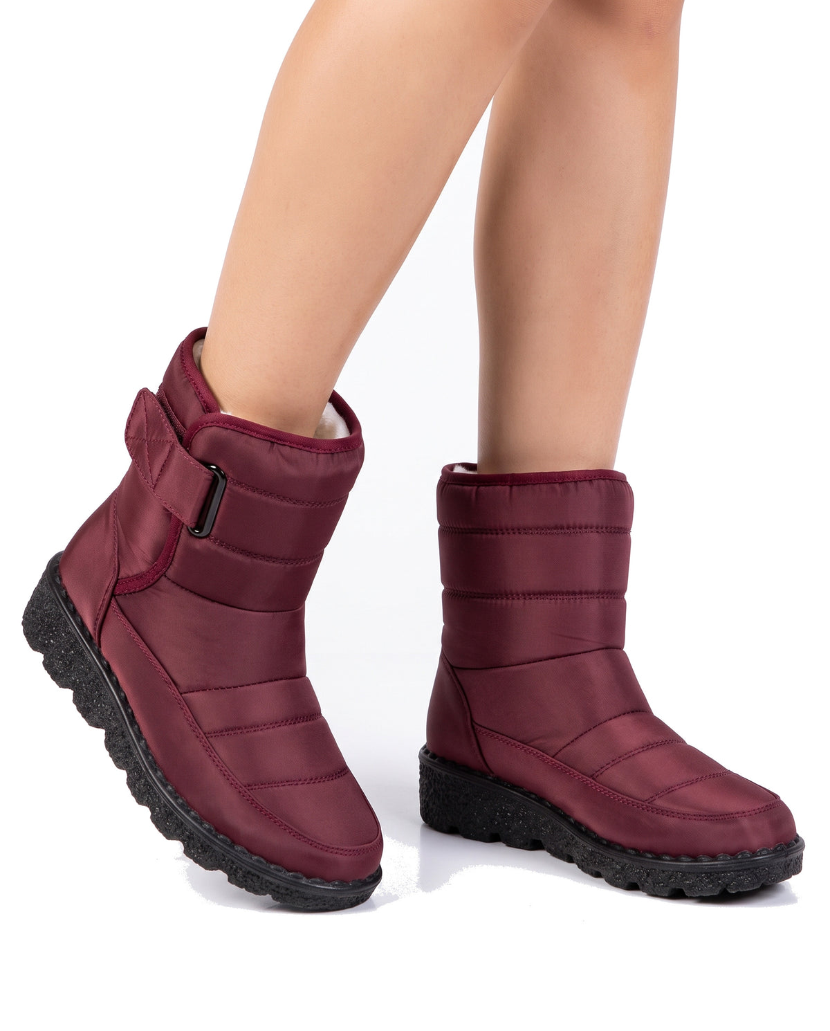 Women's fleece-lined wine red buckle-strap ankle boots worn, studio close-up