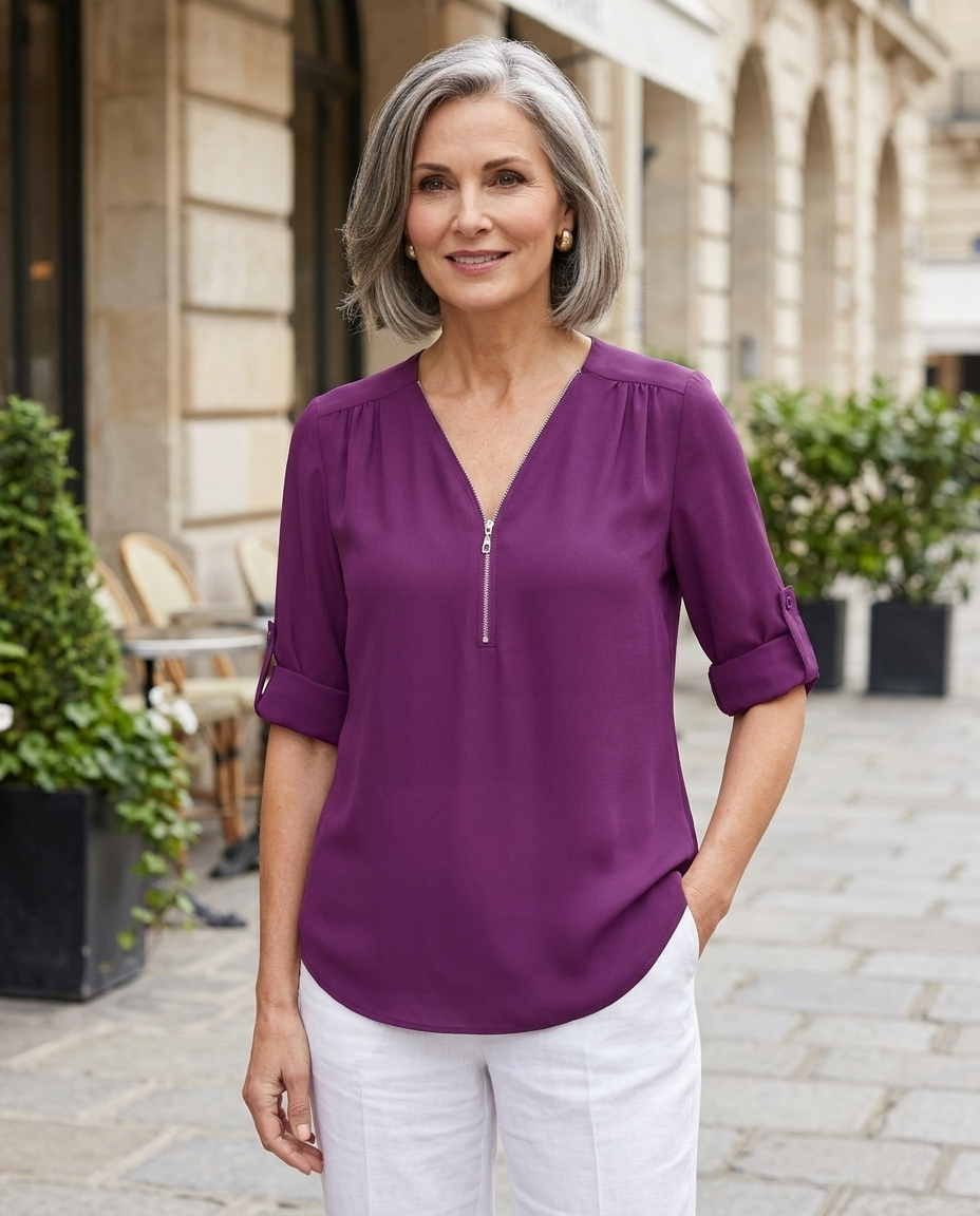 Woman in her early 50s wearing a purple zip-up V-neck half-sleeve blouse