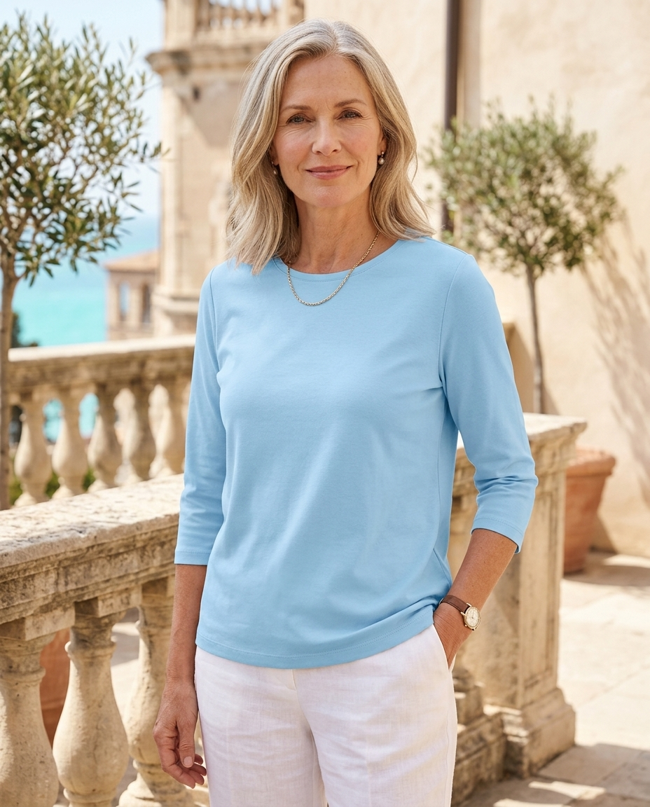 Woman in her early 50s wearing a light blue crew neck three-quarter sleeve top