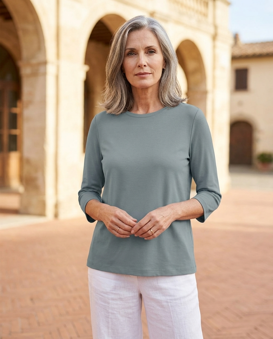 Woman in her early 50s wearing a blue crew neck three-quarter sleeve top